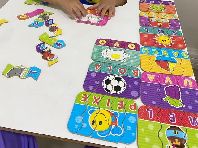 Mãos de uma criança montando palavras com peças de quebra-cabeça