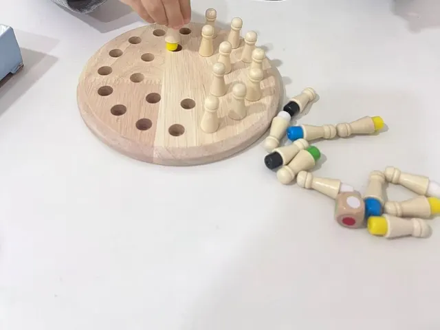 Tabuleiro de madeira com pinos coloridos de um jogo de memória